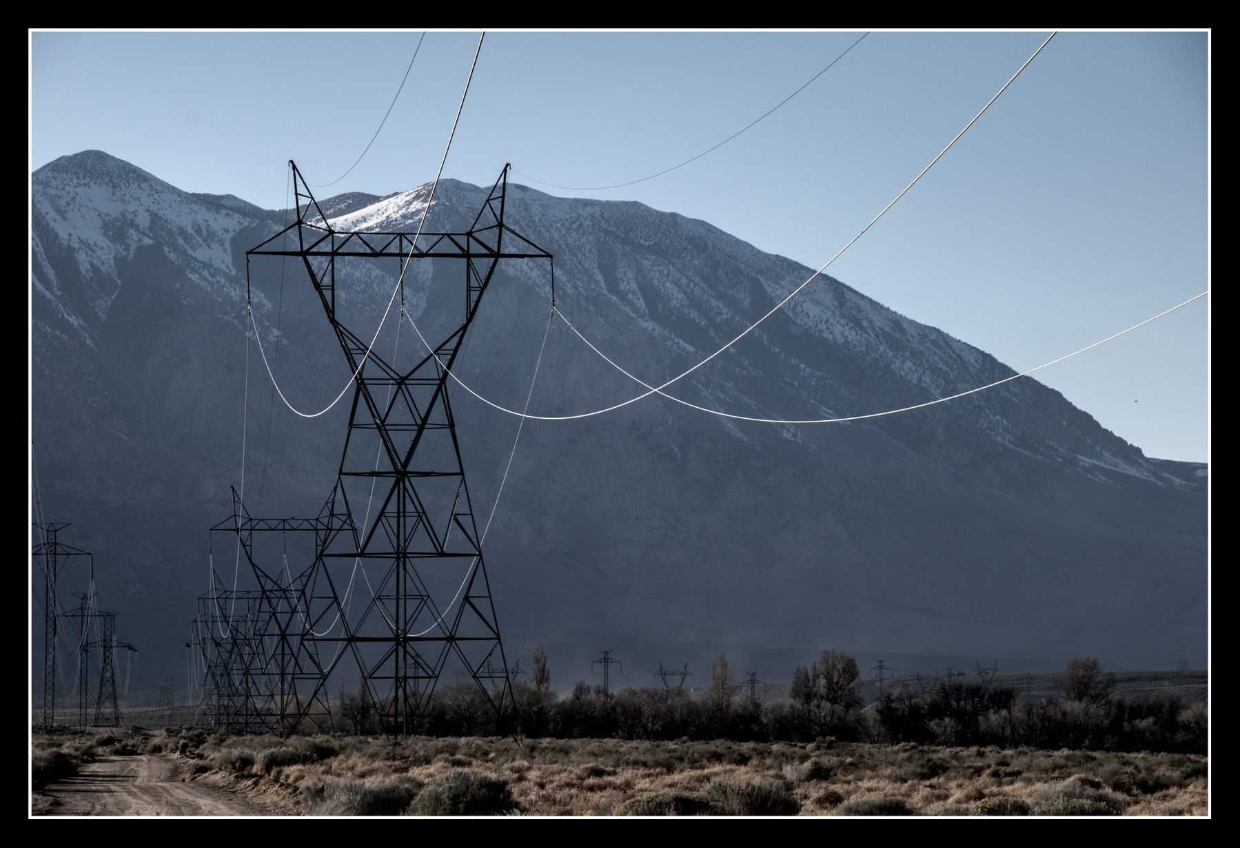 High-tension power lines run towards mountains in the background.