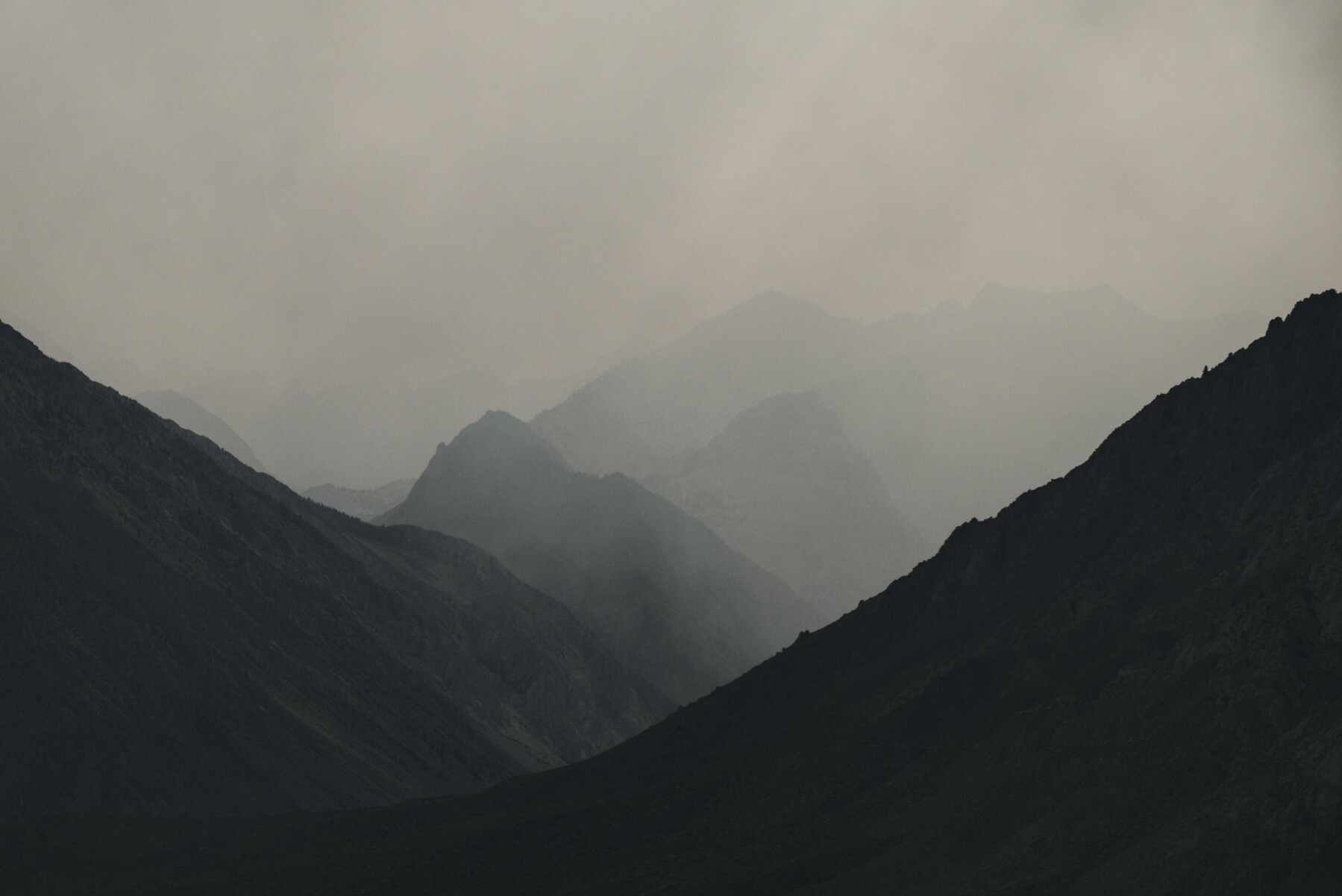 A mountain canyon is obscured by thick smoke.