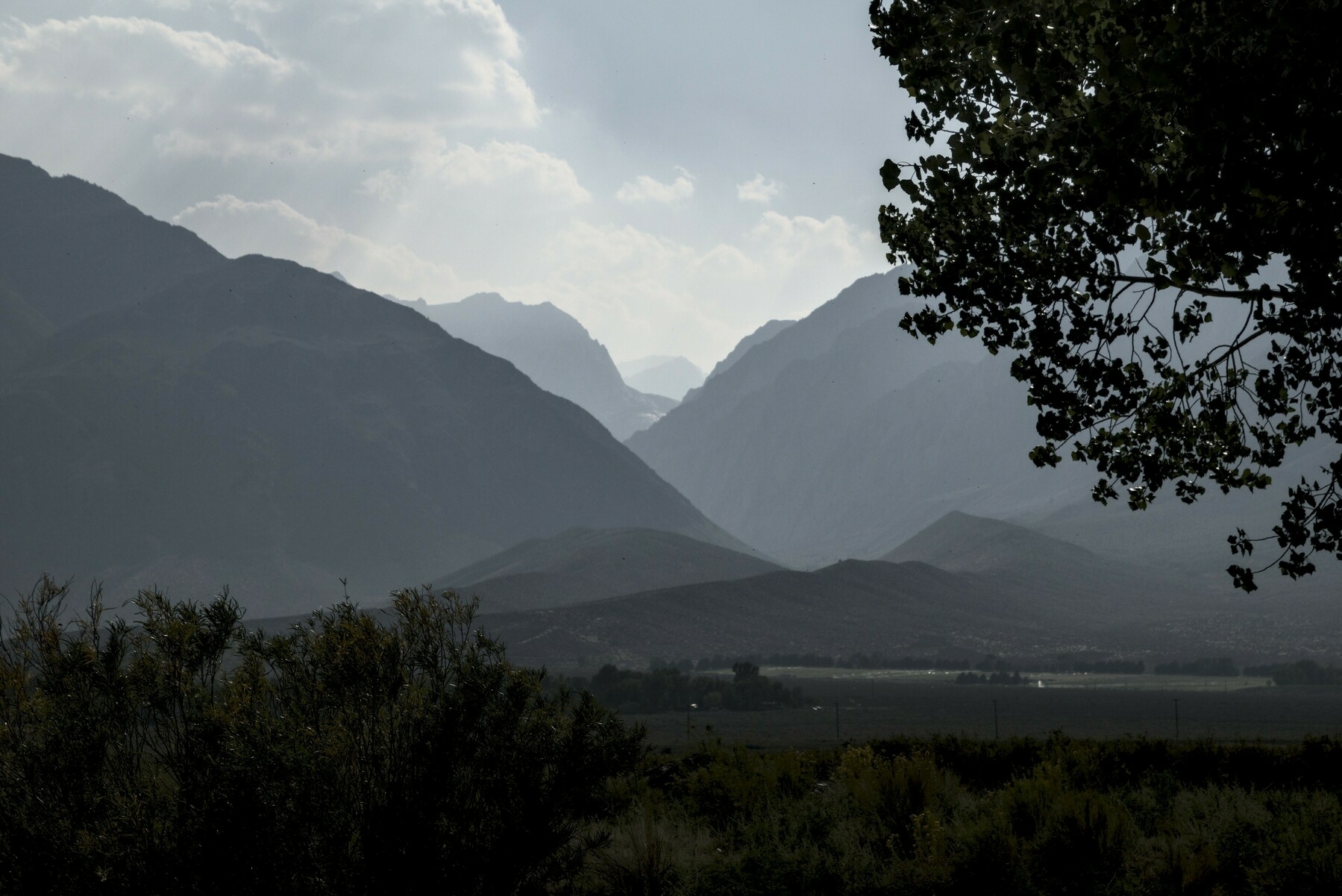A mountain valley is partially obscured by smoke.