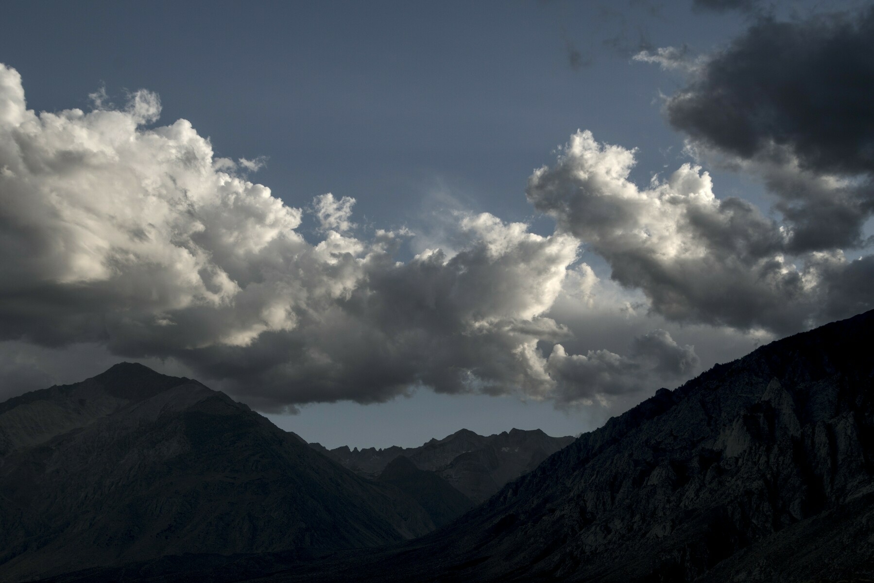 Cumulonimbus clouds over a mountain ridge.