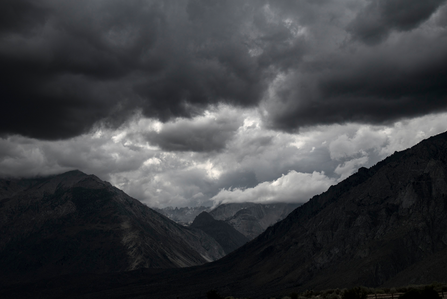 A storm gathers over a mountain valley.
