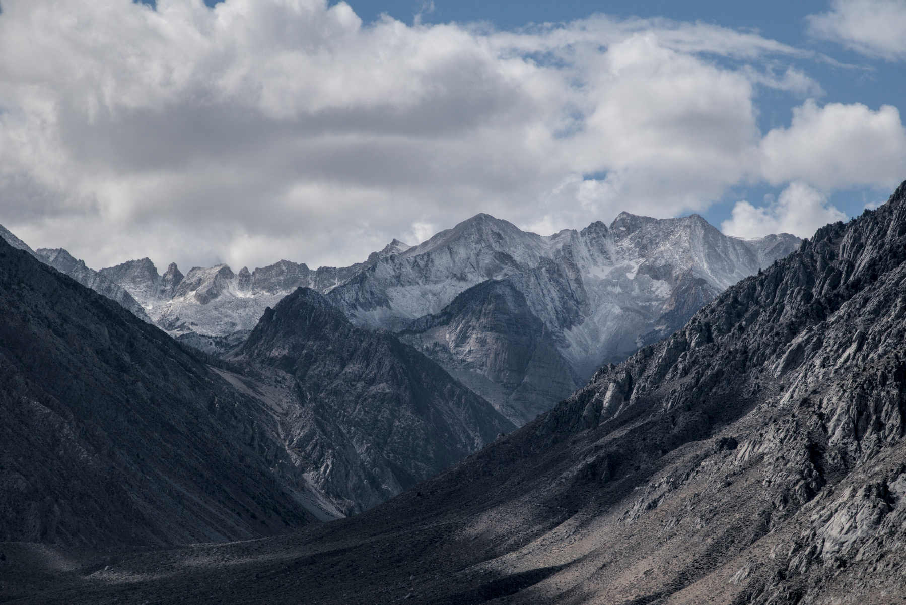 Jagged mountains in the distance have a light dusting of new snow.