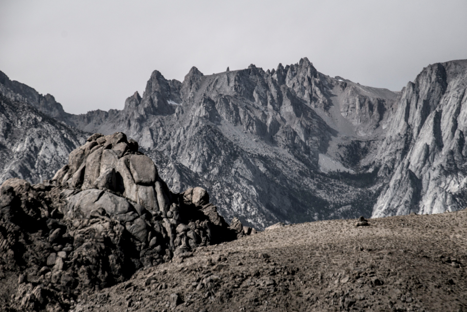 Dusty brown hills in the foreground, granite peaks in the background.