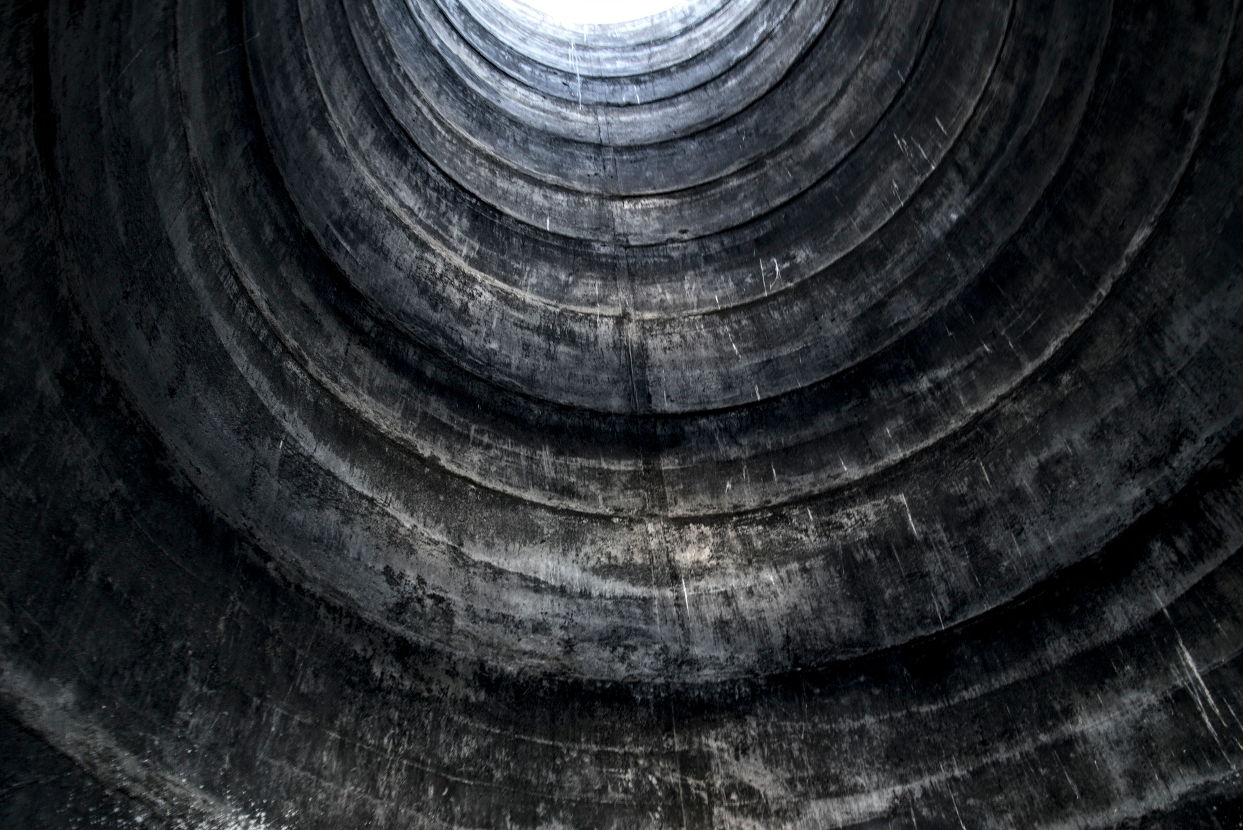 Looking up inside a big concrete cylindrical structure, with rings of poured concrete levels distinctly visible.